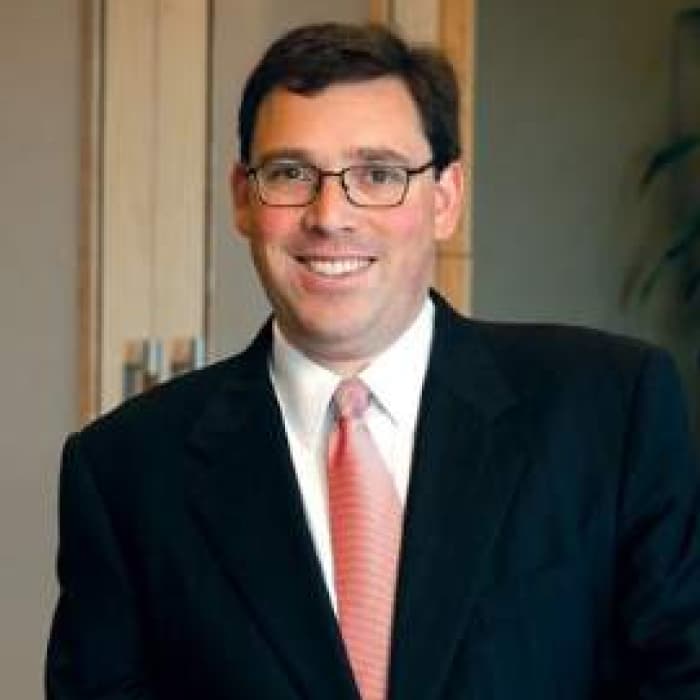 Portrait of Michael Sacopulos, JD wearing a suit and smiling