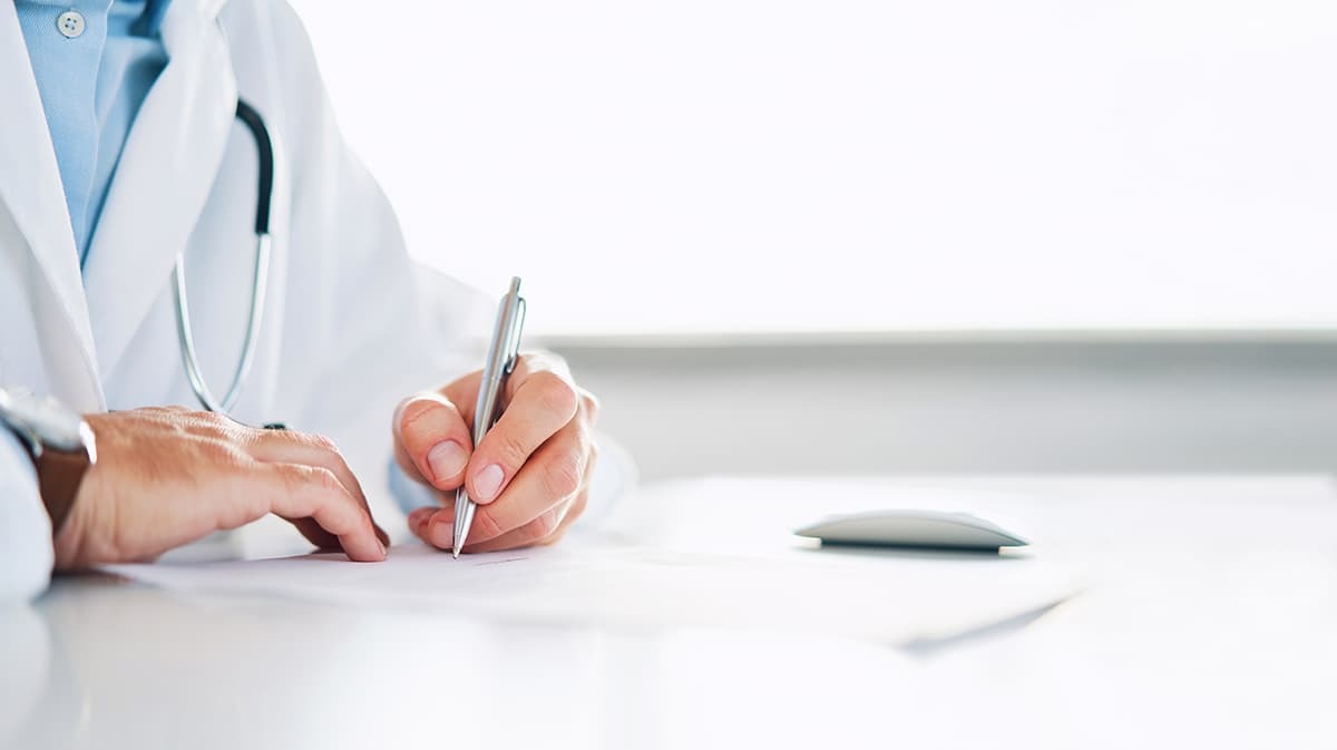 Close up of doctor writing notes with a pen