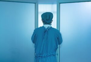 Back of doctor opening doors to operating room