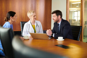 Two medical professionals talking to a lawyer