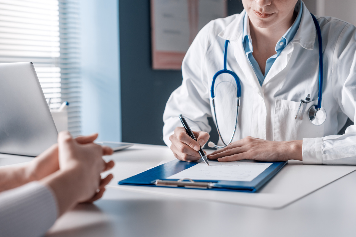 Doctor sitting at desk and filling out patient file