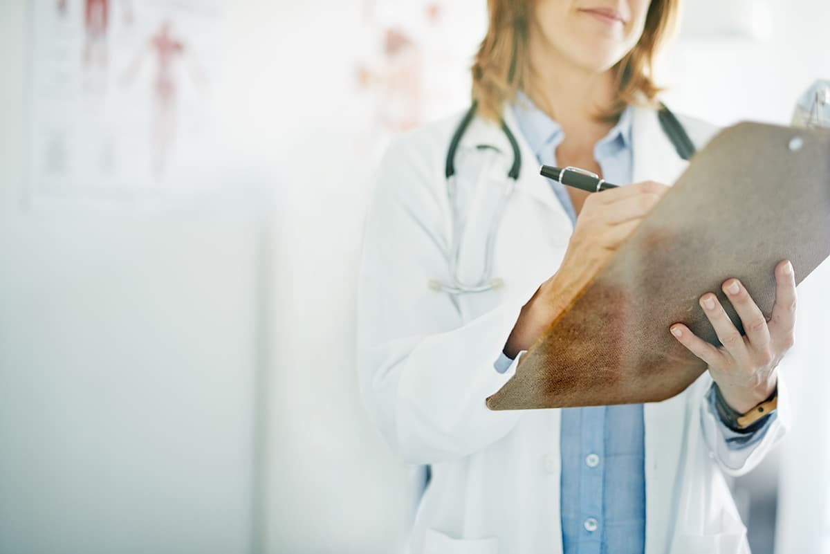 Female medical practitioner taking notes on a clipboard