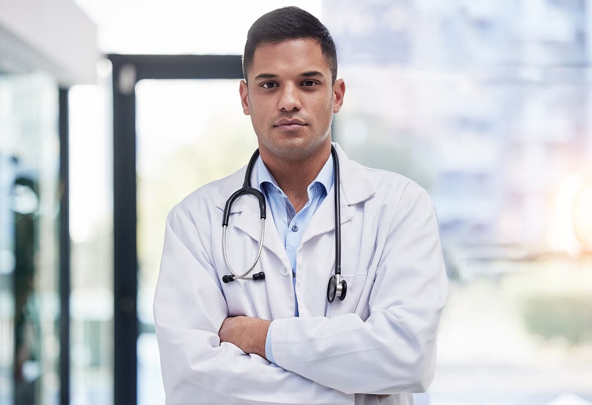 Serious man wearing medical coat and stethoscope