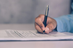 Close up of hand filling out a form