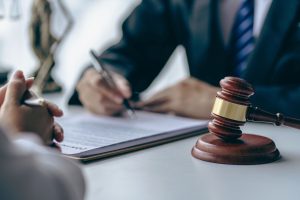 Signing of a legal document next to a gavel