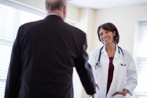 Lawyer in a suit shaking hands with a smiling female doctor