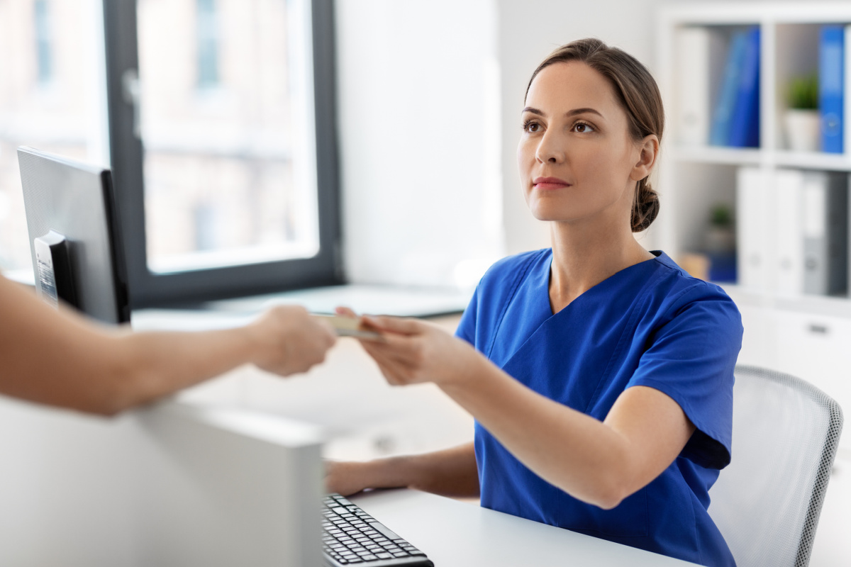 Female physician taking card as form of payment from a patient