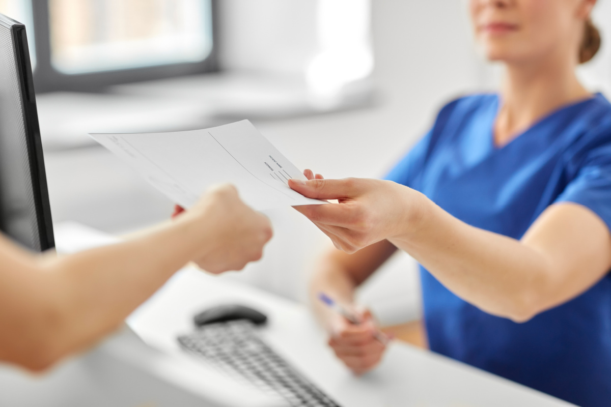 Female physician handing copy of medical records to a patient