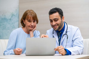 Young male physician showing his mother how to leave him a positive review on Google