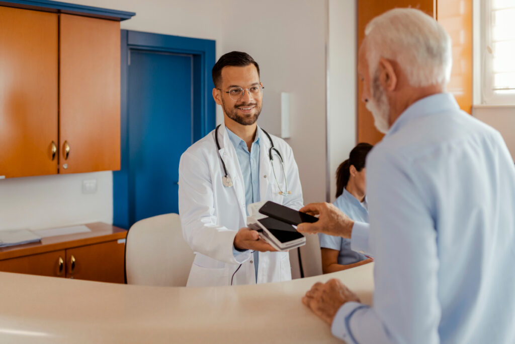Male physician asking a patient for a review during checkout