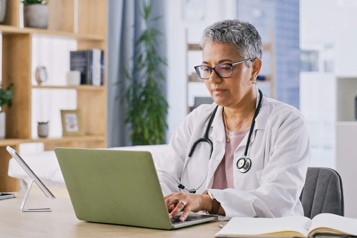 Female physician replying to a negative review on her computer