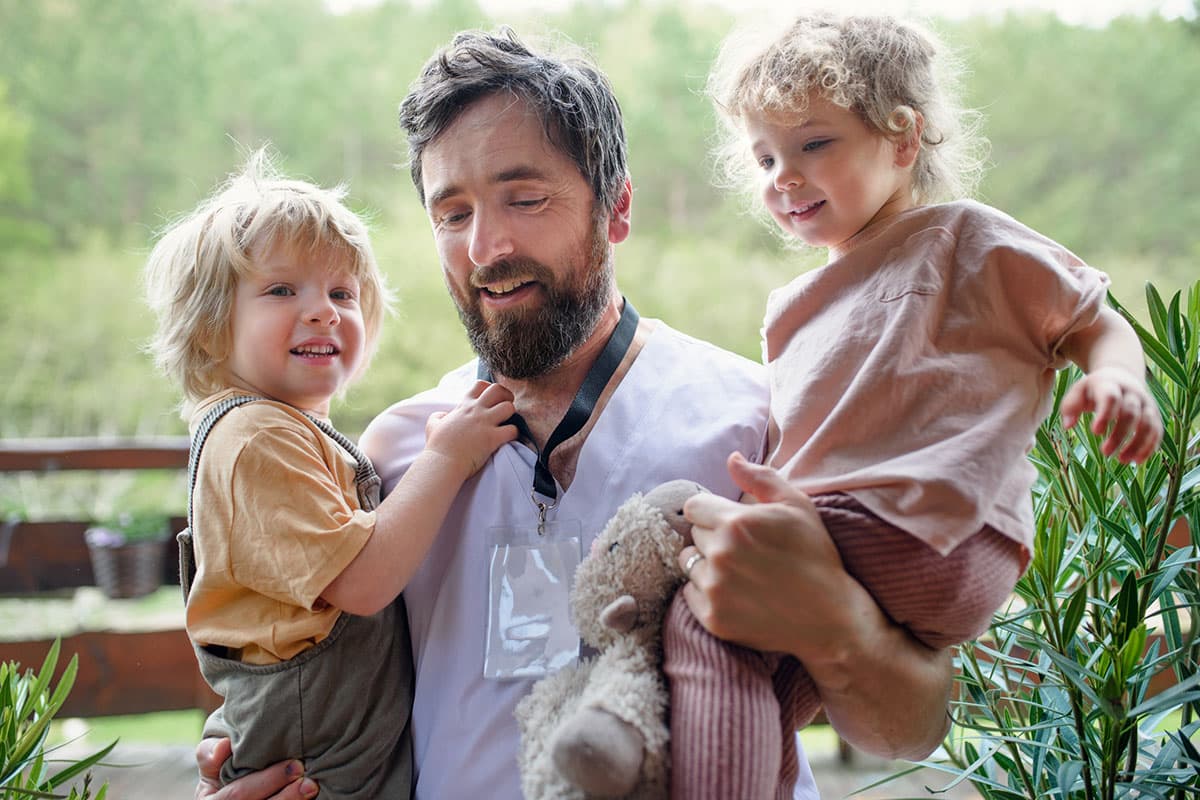 Male doctor holding his two children