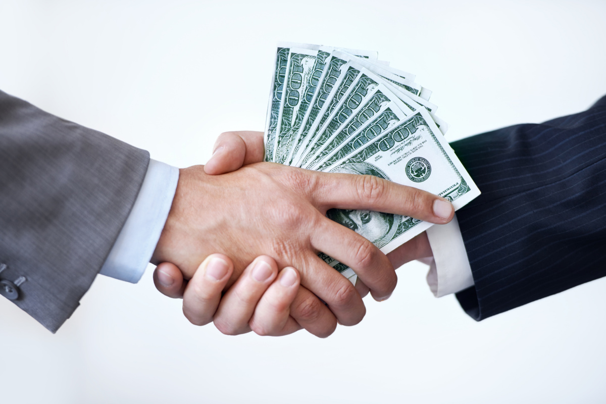 Two hands in suits exchanging money