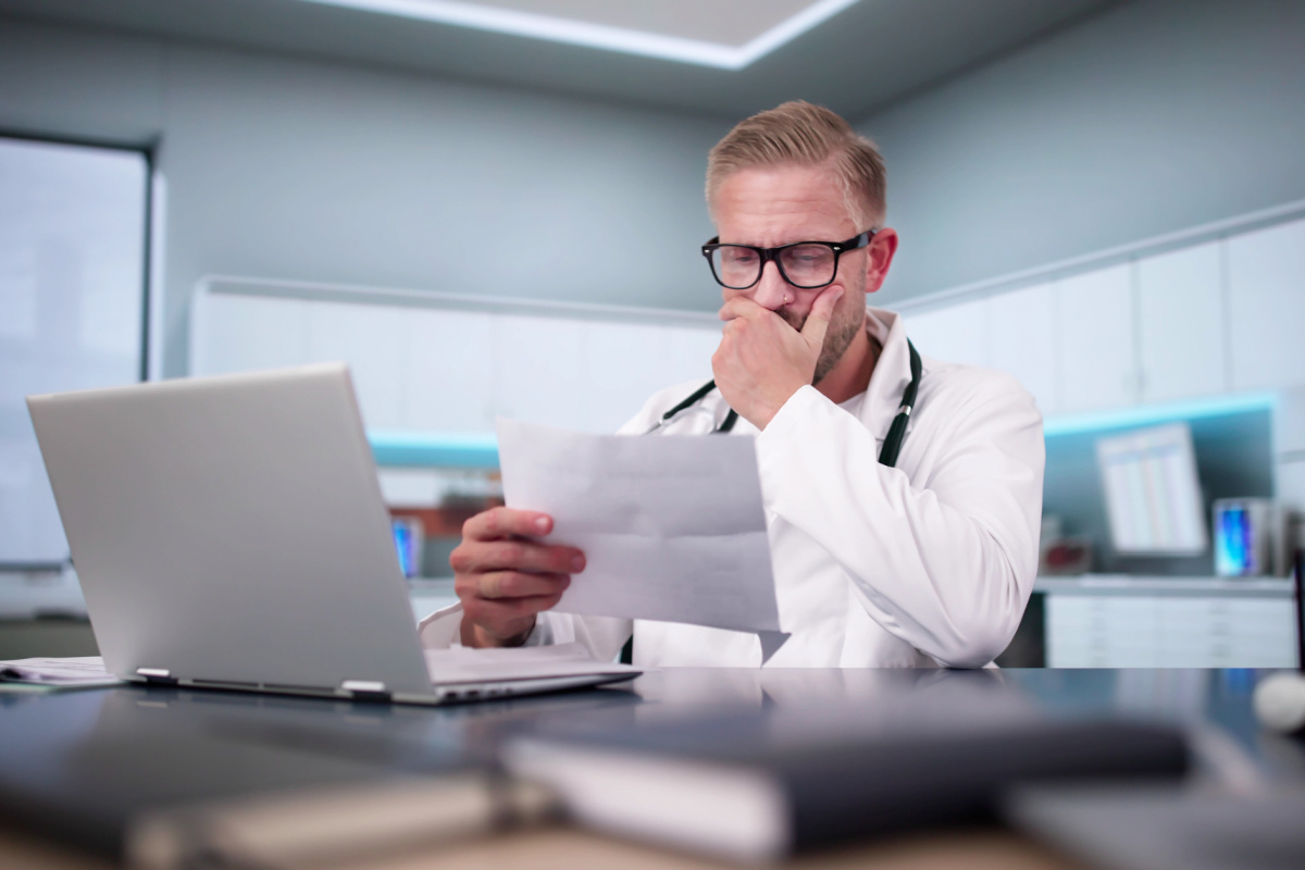 Male doctor frowning at lawsuit small claims court summons