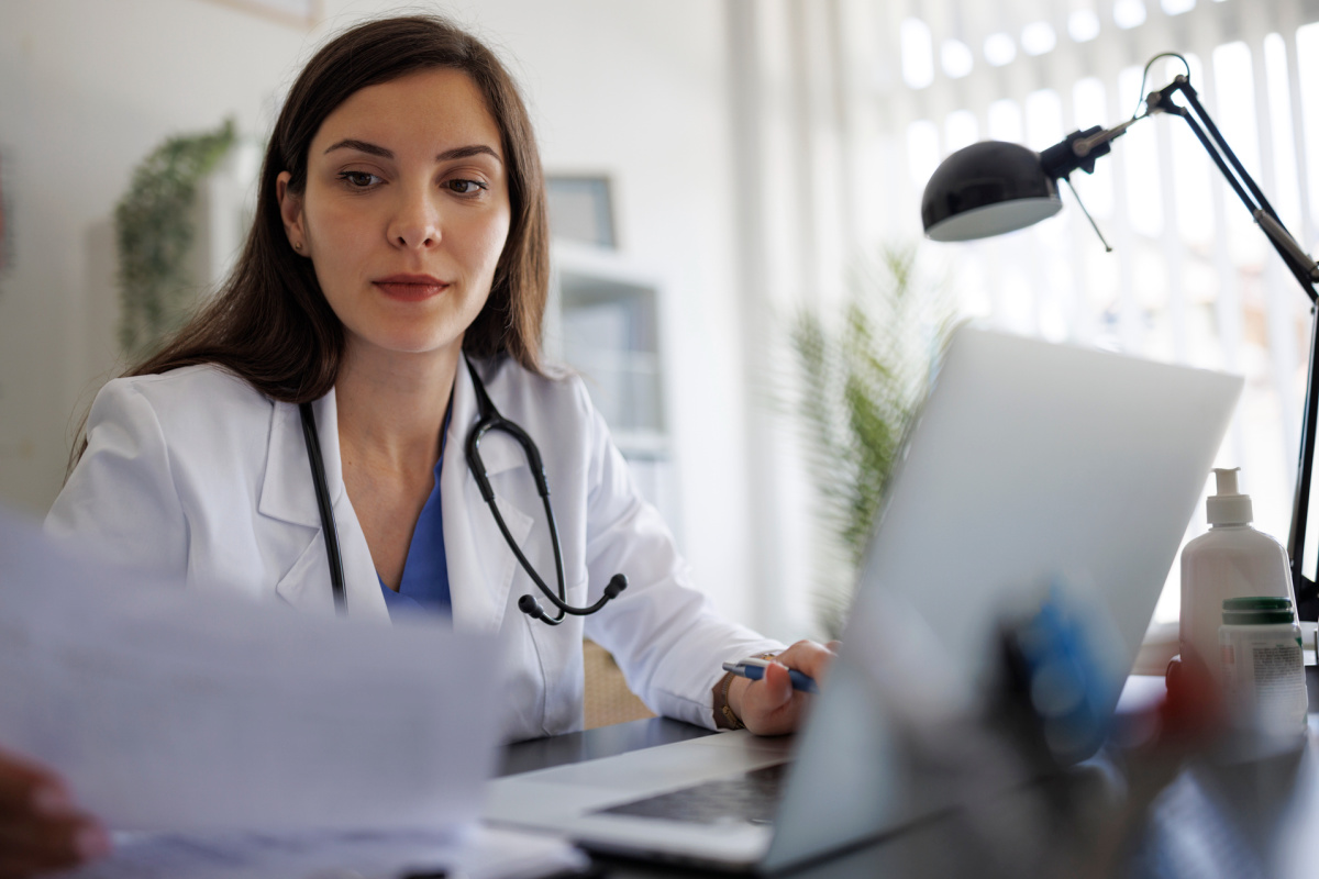 Female physician reading about malpractice insurance