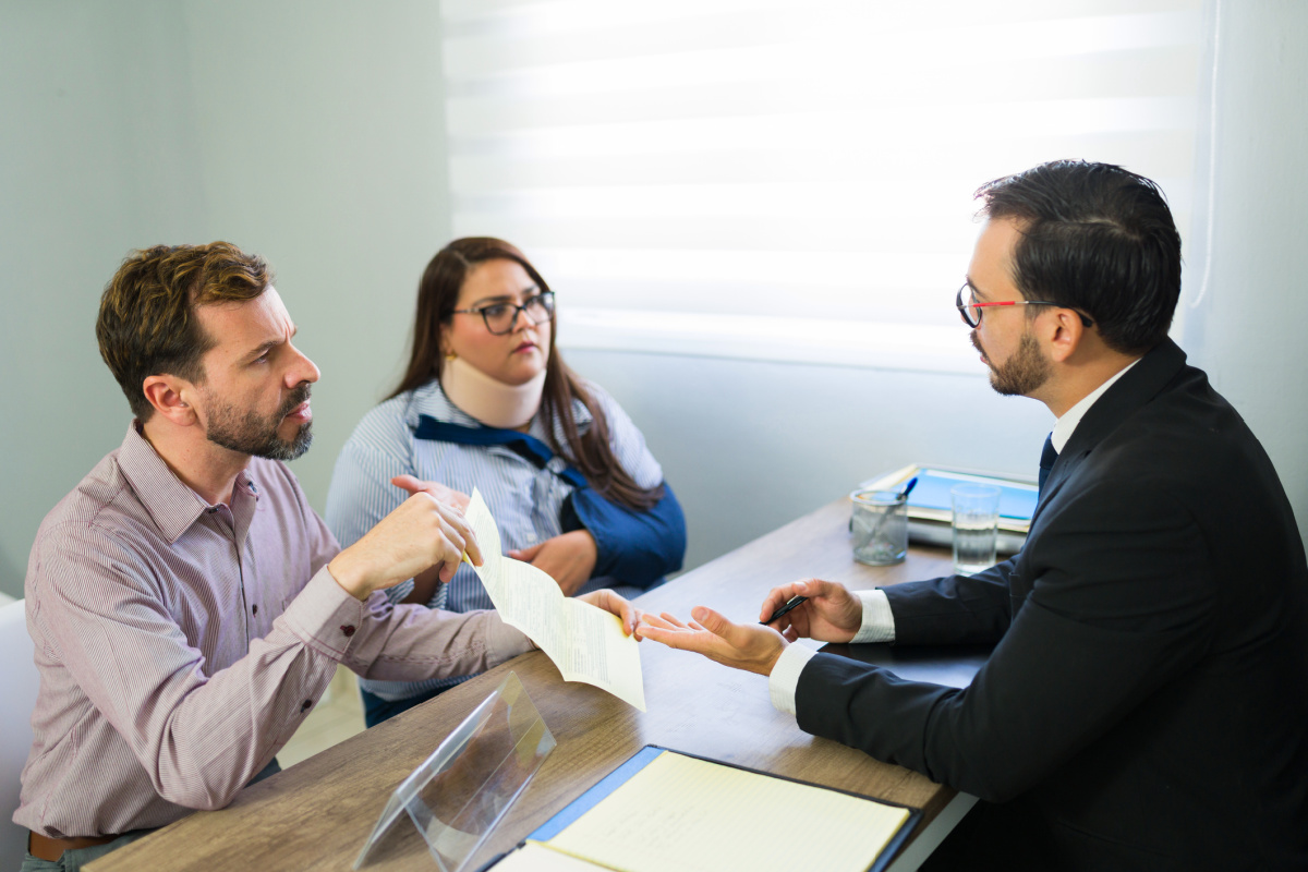 Couple discussing filing a lawsuit against a physician with a medico-legal lawyer after woman was harmed by malpractice