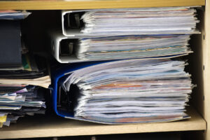 Overstuffed cabinet and folders with paperwork