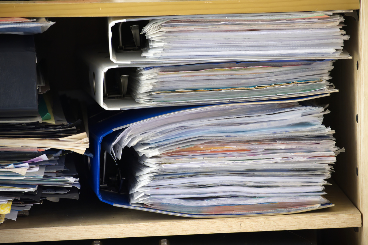 Overstuffed cabinet and folders with paperwork