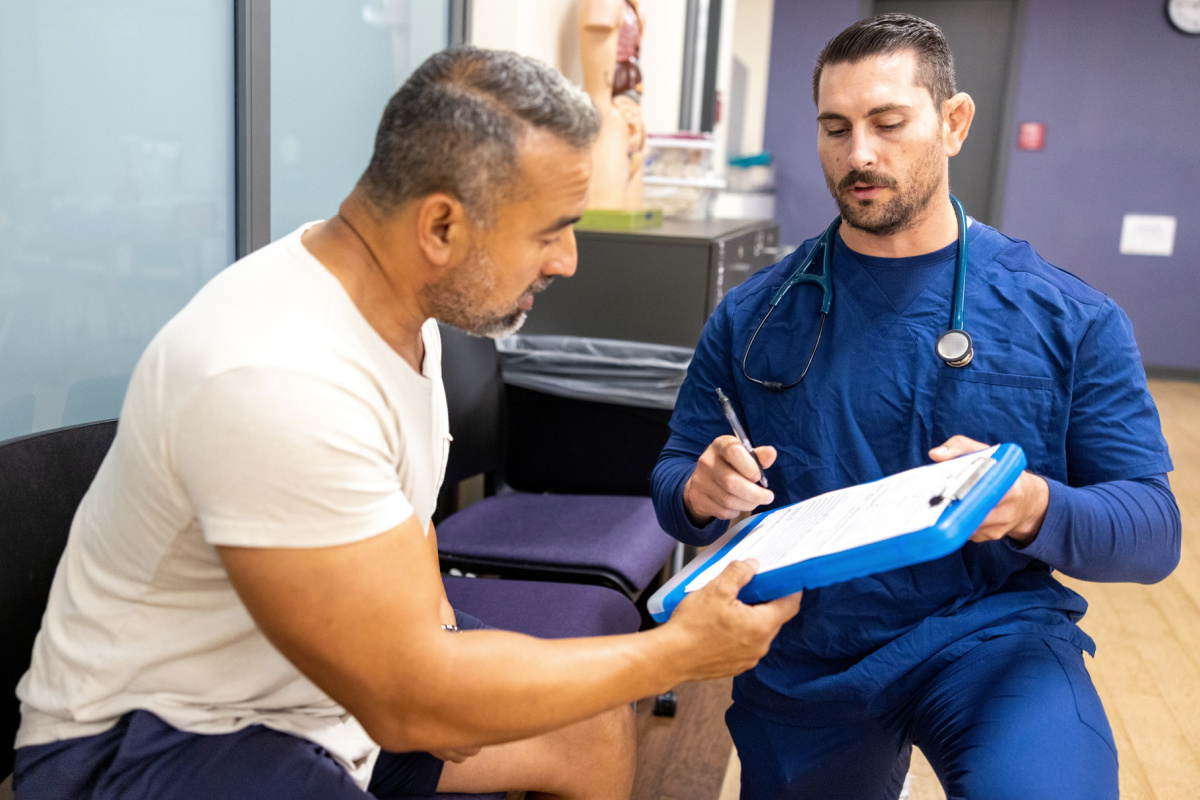 Male physician having patient sign a HIPAA form