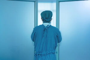 Anesthesiologist leaving operating room during surgery