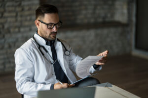 Male physician reviewing a contract for indemnification traps