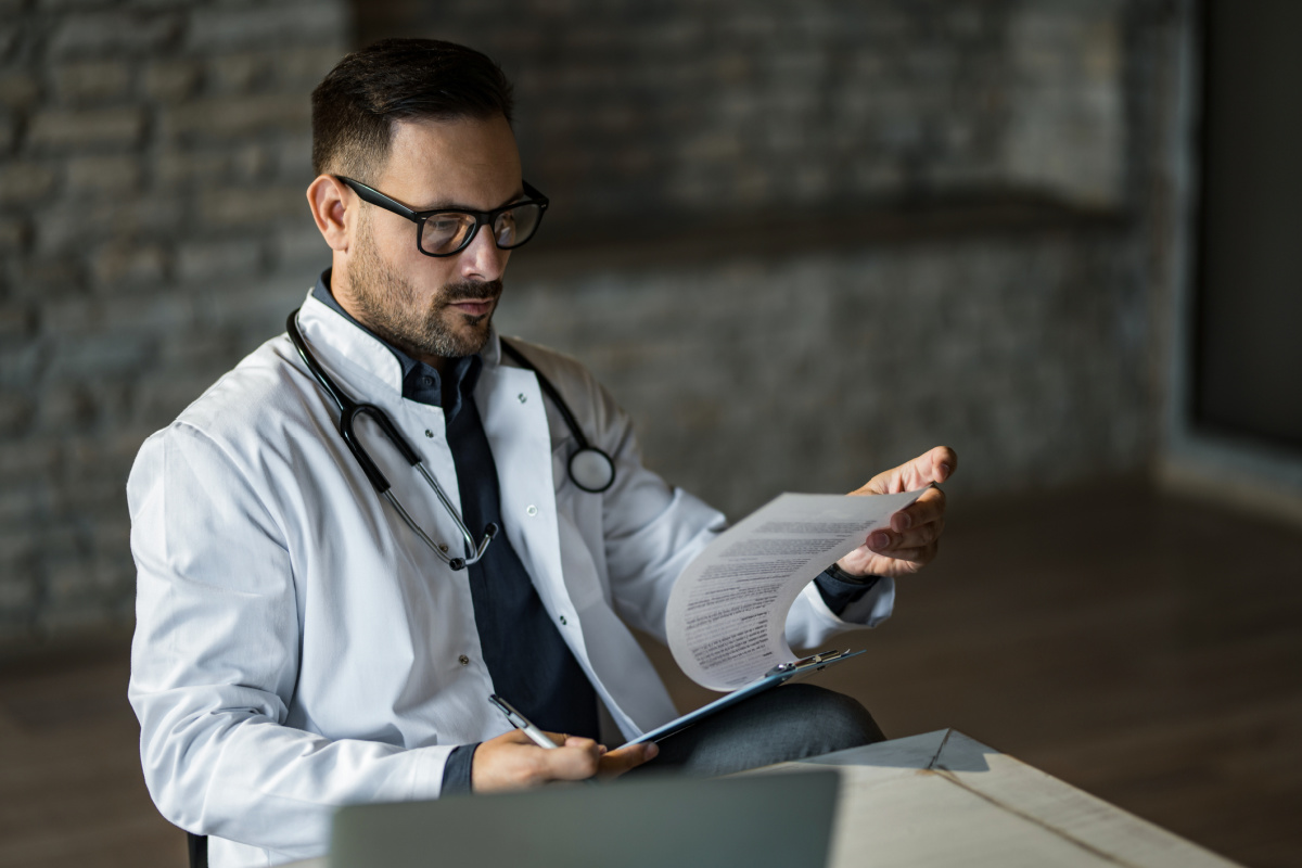 Male physician reviewing a contract for indemnification traps