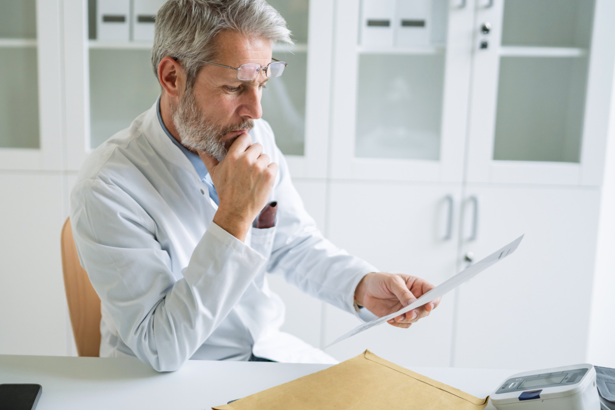 Male physician looking over government mail