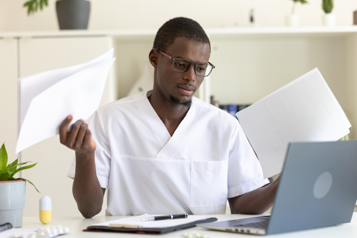 Young male physician confused by poor medical documentation and EMRs